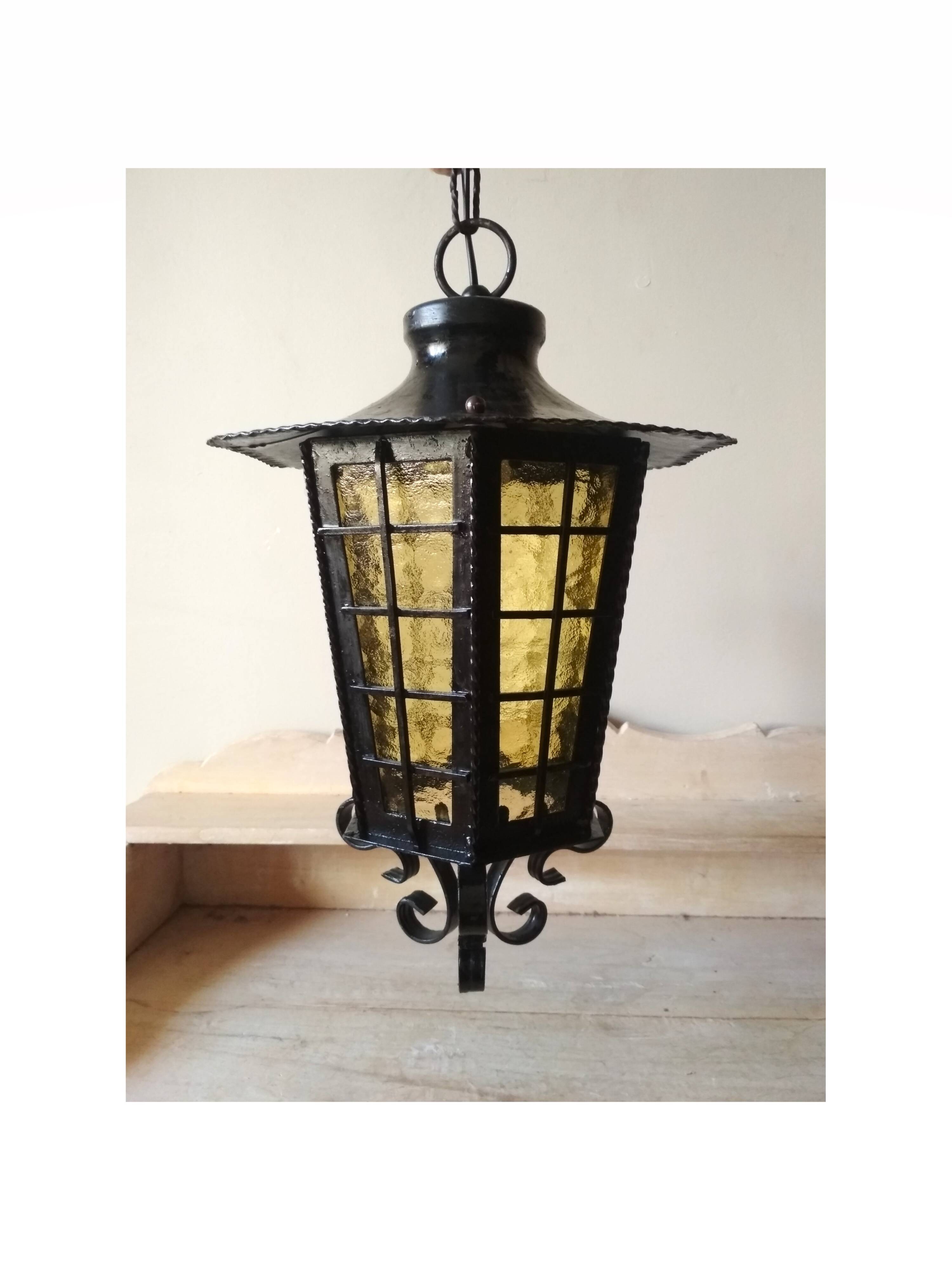 Large hanging lantern in wrought iron and opaque yellow-orange windows