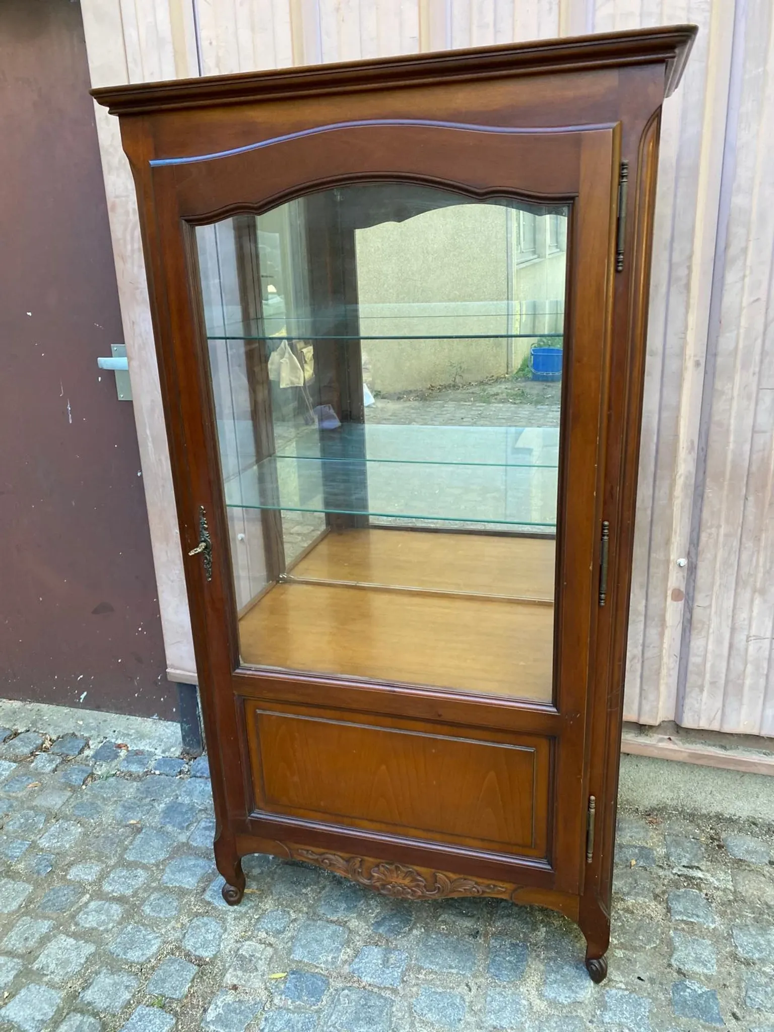 Louis XV style display cabinet in cherry wood with a mirrored back and glass shelves.