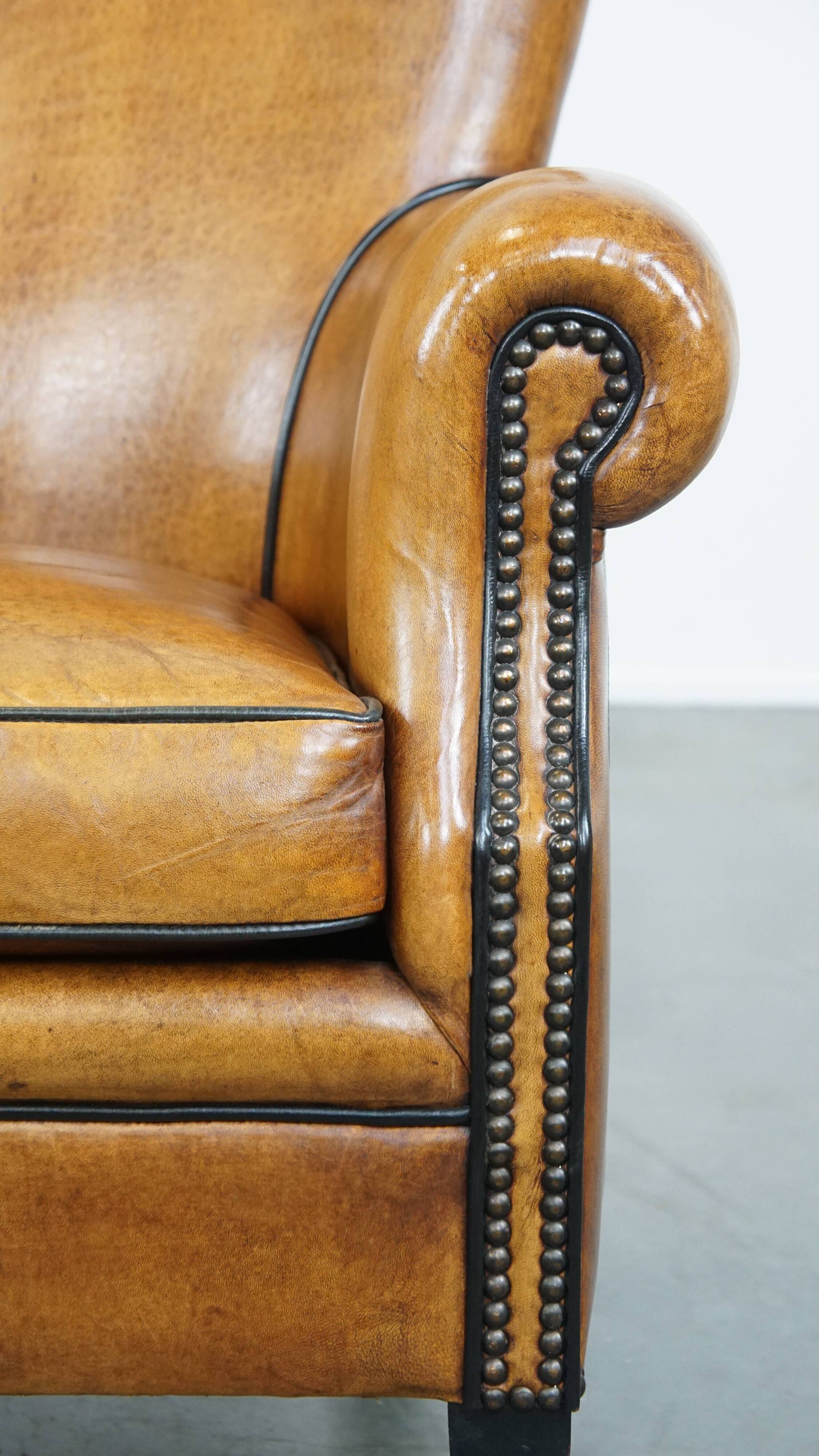 Cognac-colored sheep leather armchair finished with decorative nails