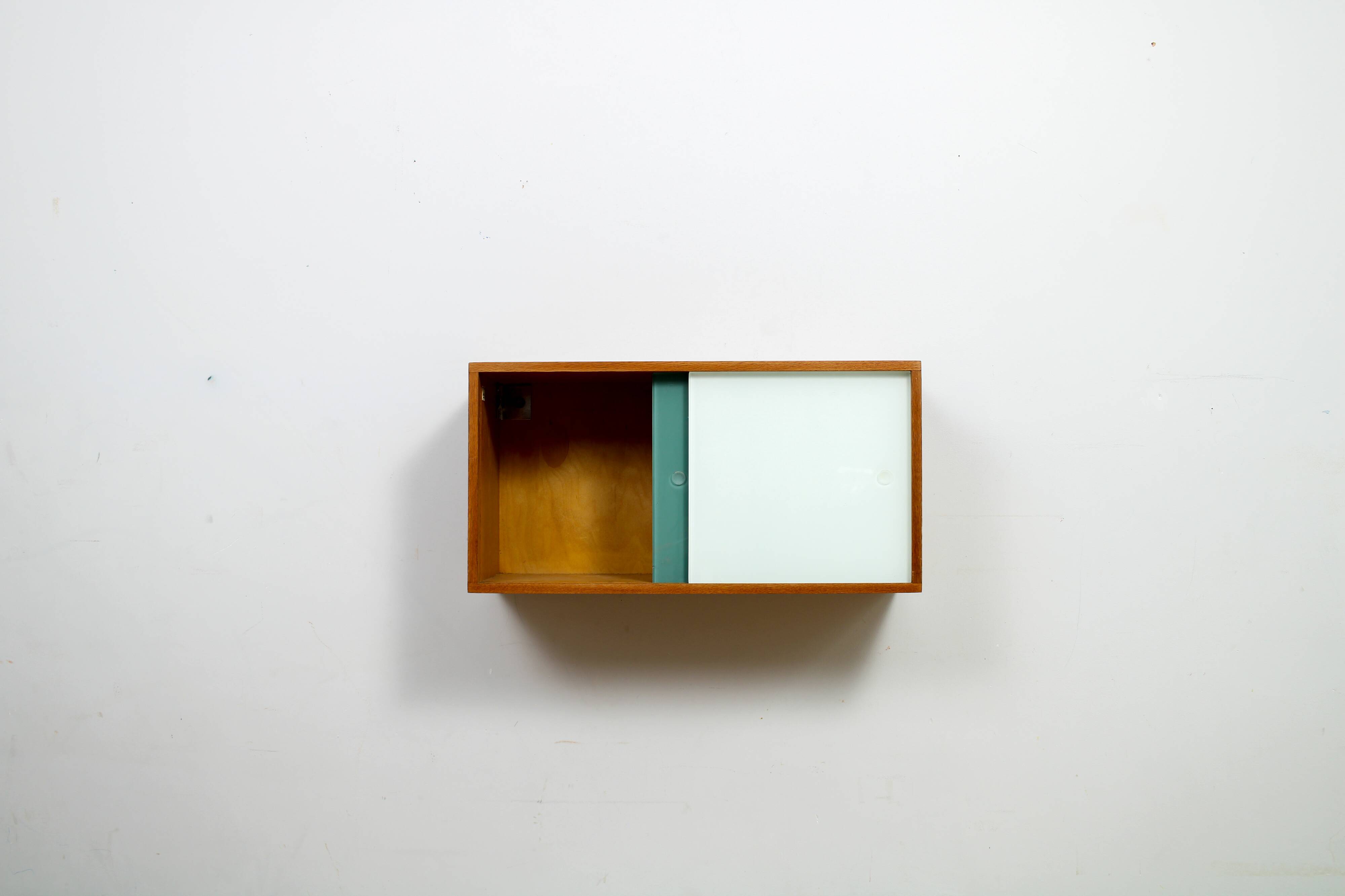 A vintage mid-century wall hung oak cabinet, green & white glass doors