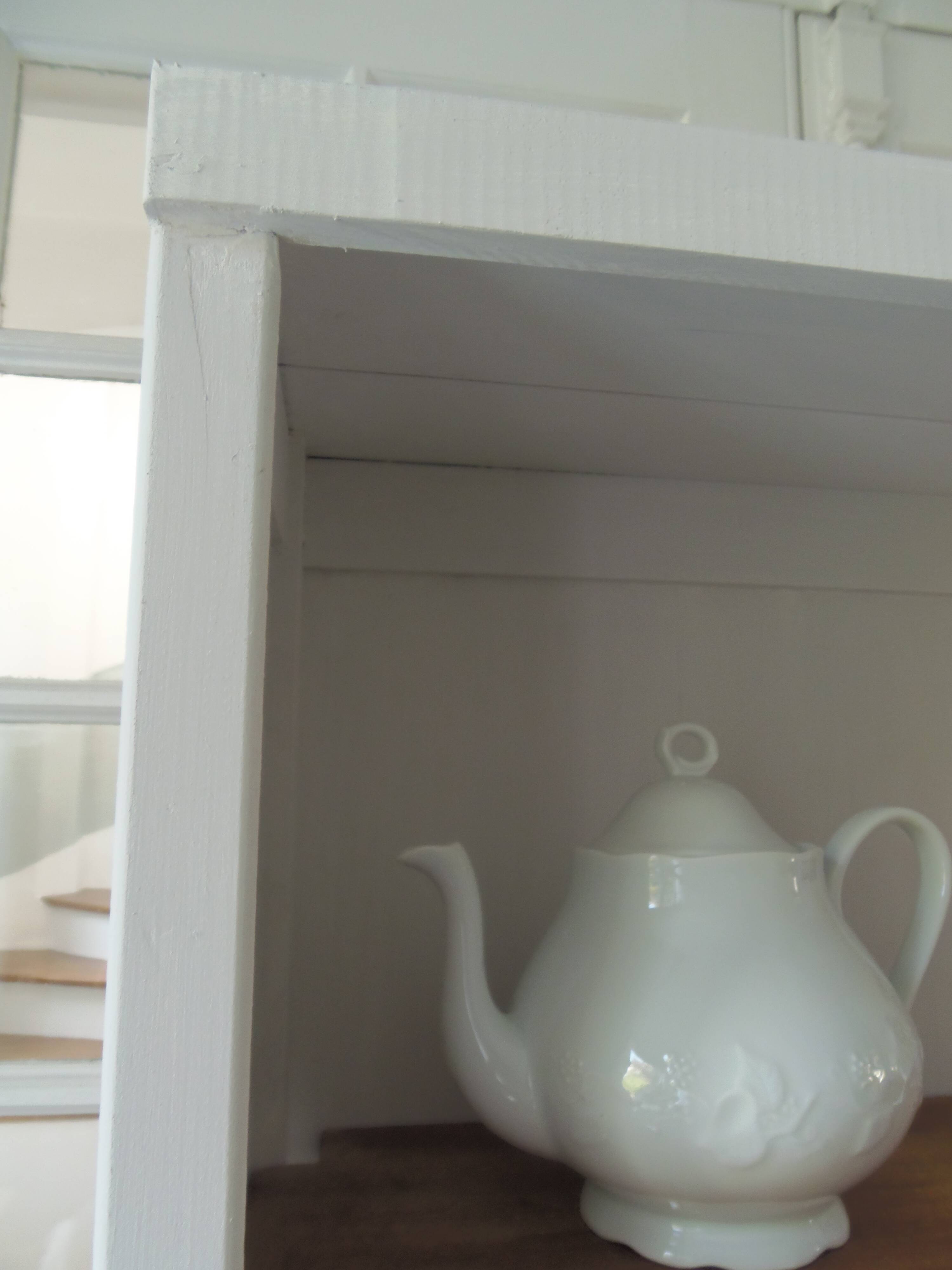 Shallow depth bookcase re-enchanted in pearl gray, wooden shelves.