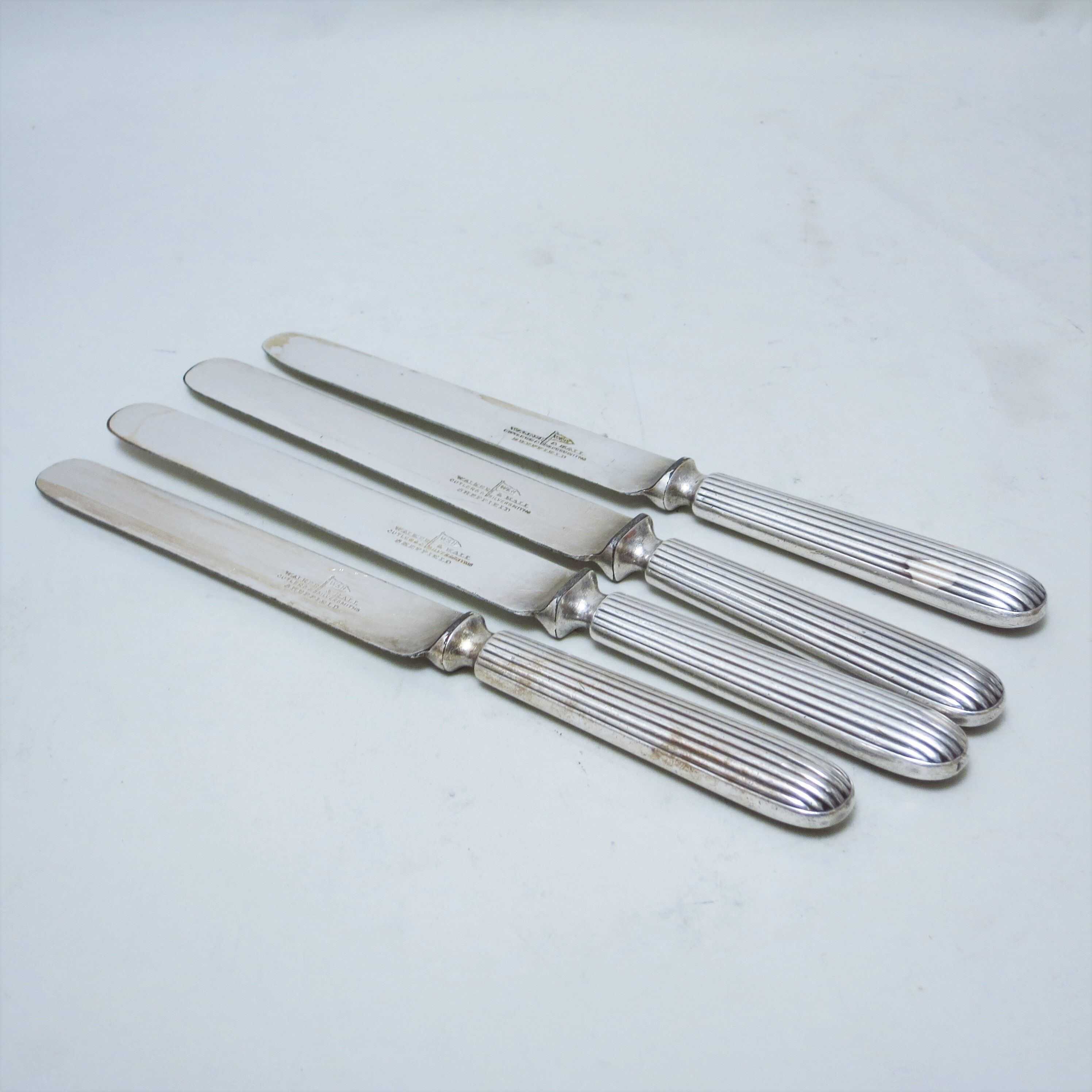 Set of four silver metal knives