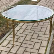 Round coffee table in gilded brass with a transparent glass top, 1960s design.
