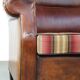 Very large worn sheepskin wing chair with a checked seat cushion