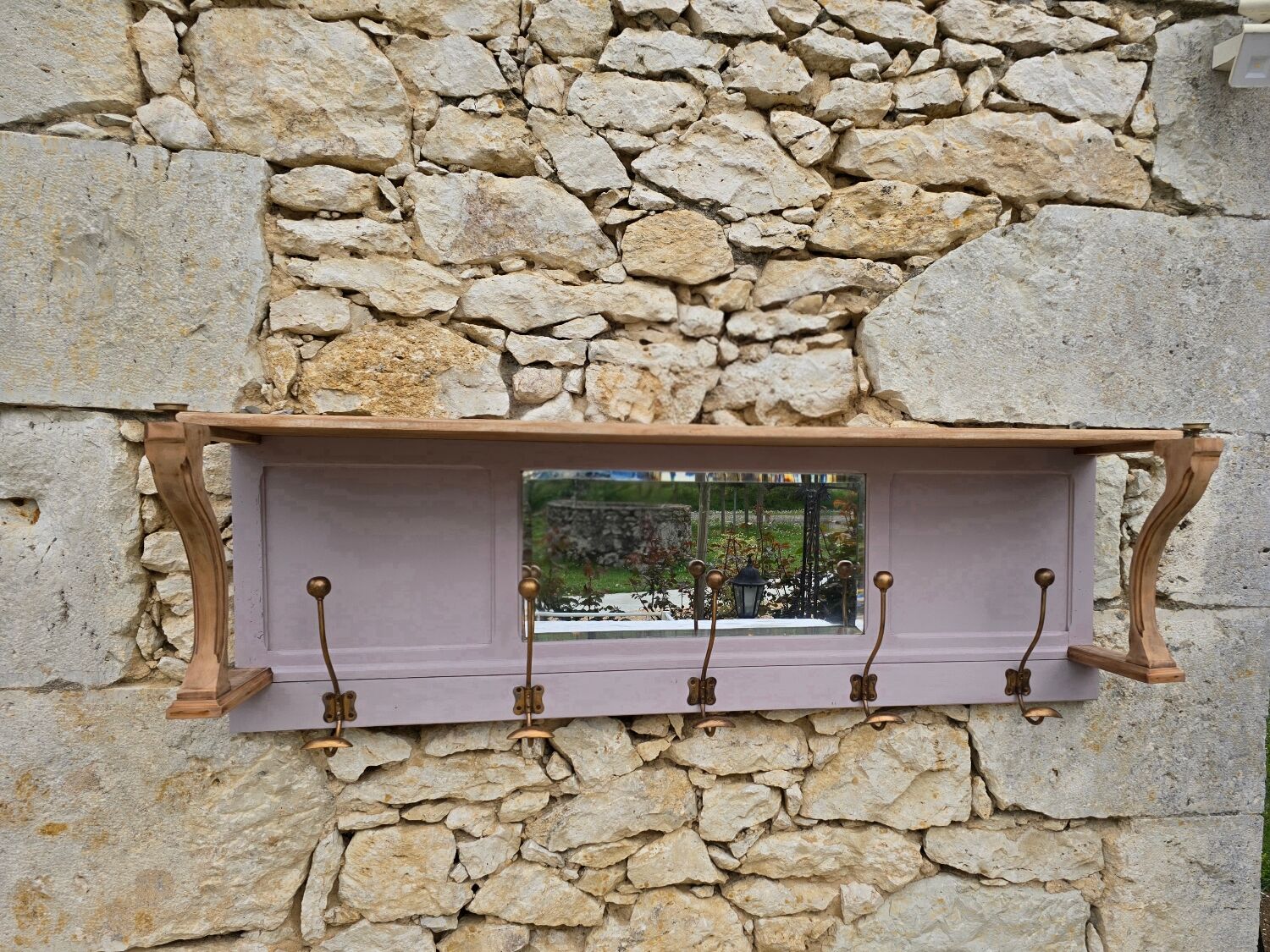 Coat rack or wall-mounted entrance wardrobe with scroll arms and antique hooks.