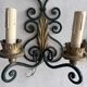 Pair of wall sconces in wrought iron with golden leaf patterns.