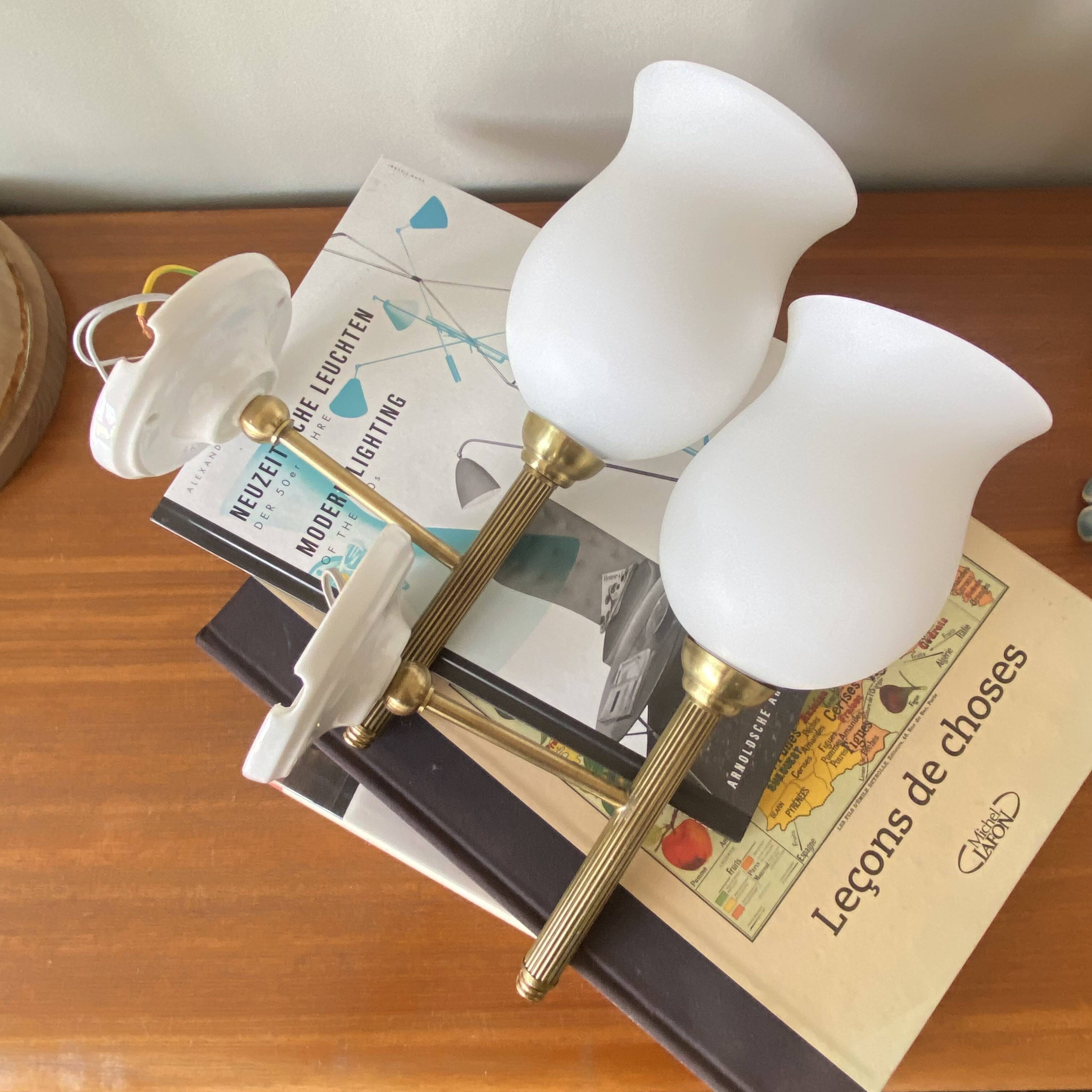 Pair of torch wall lights in brass, white glass and porcelain.