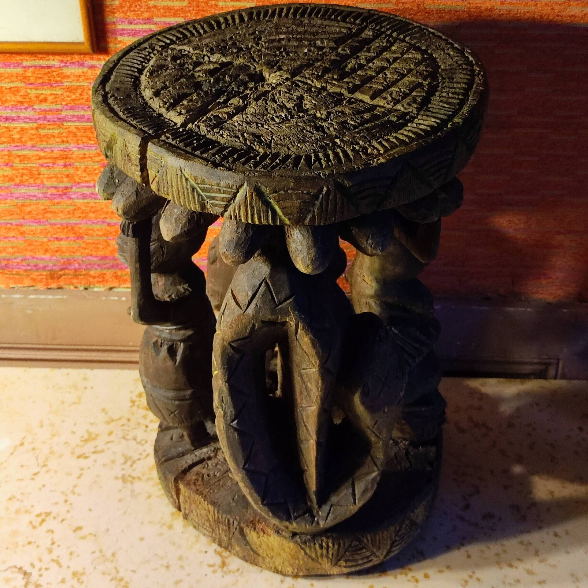 African wooden stool carved in the shapes of characters