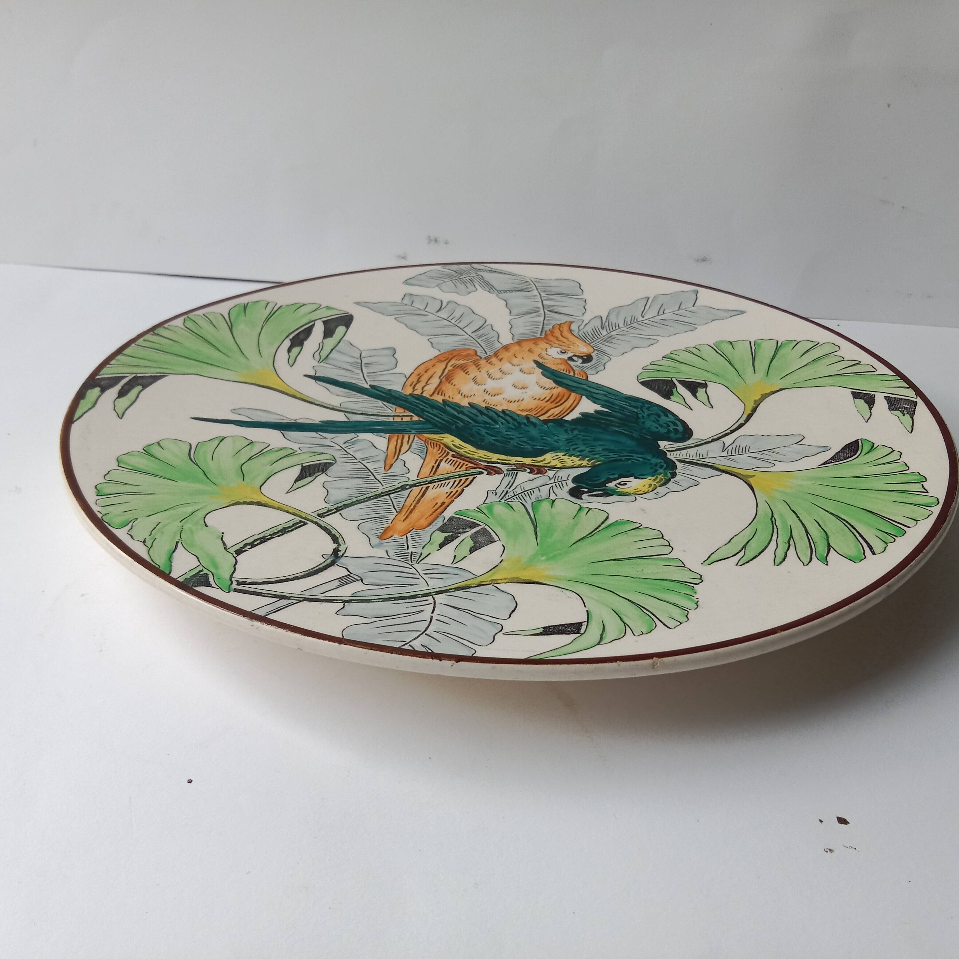 Plat rond à décor de perroquets dans la jungle, circa 1900