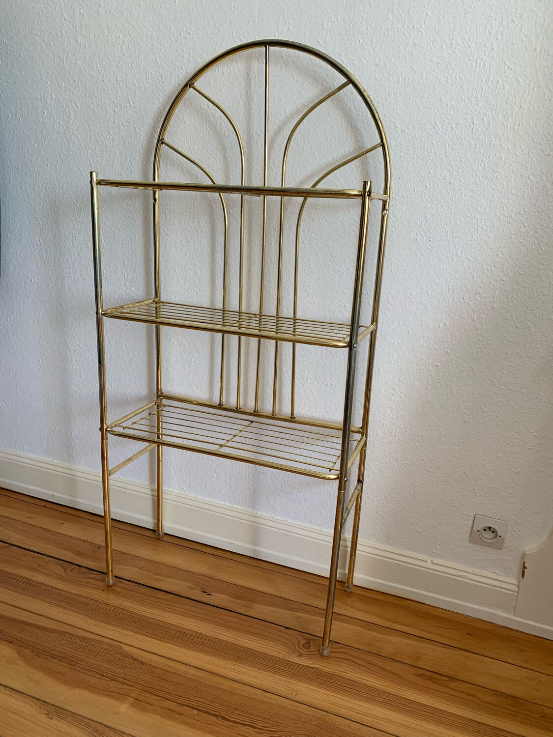 Gilded metal grid shelf in the shape of a vaulted arch