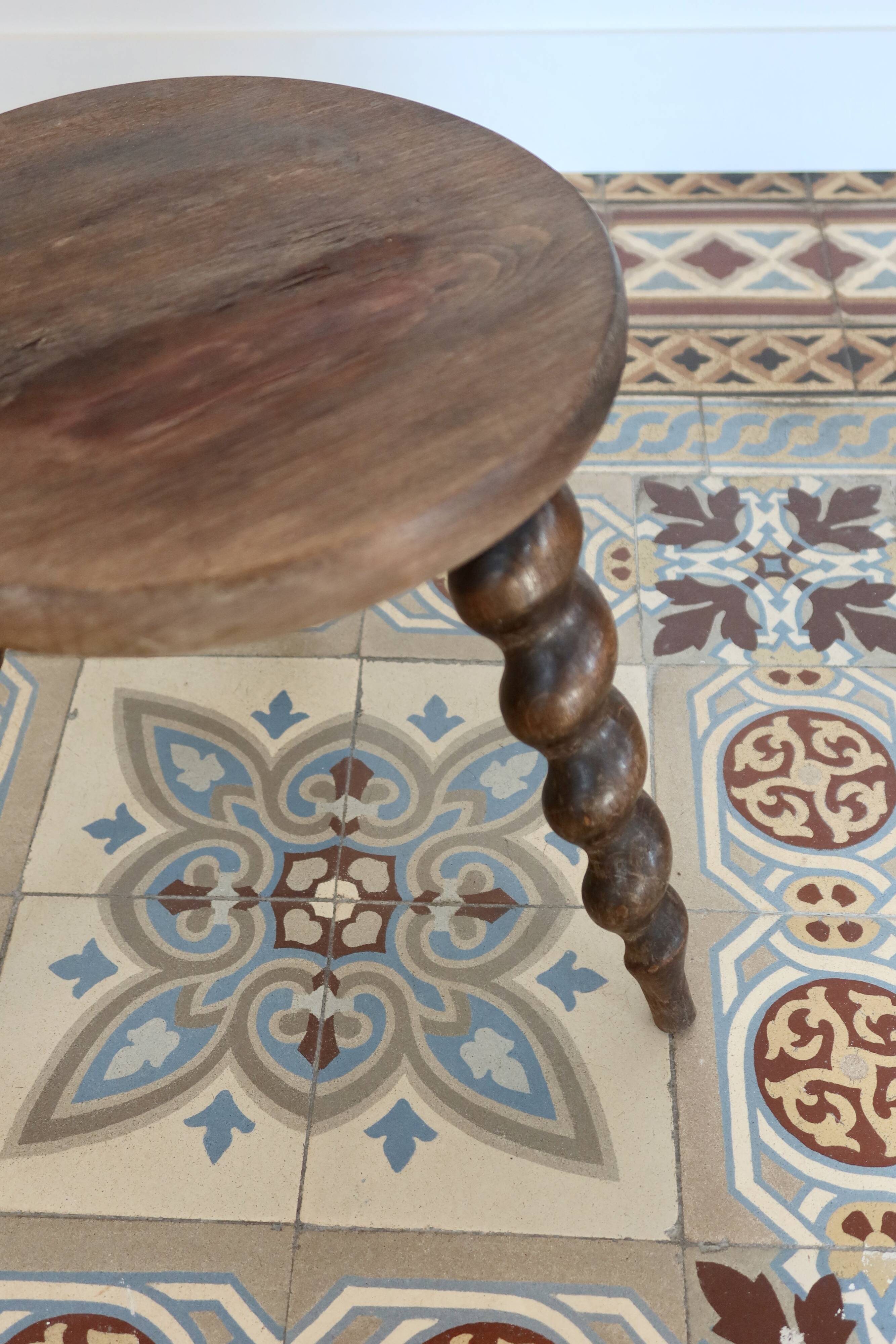 Antique tripod stool made of turned wood.