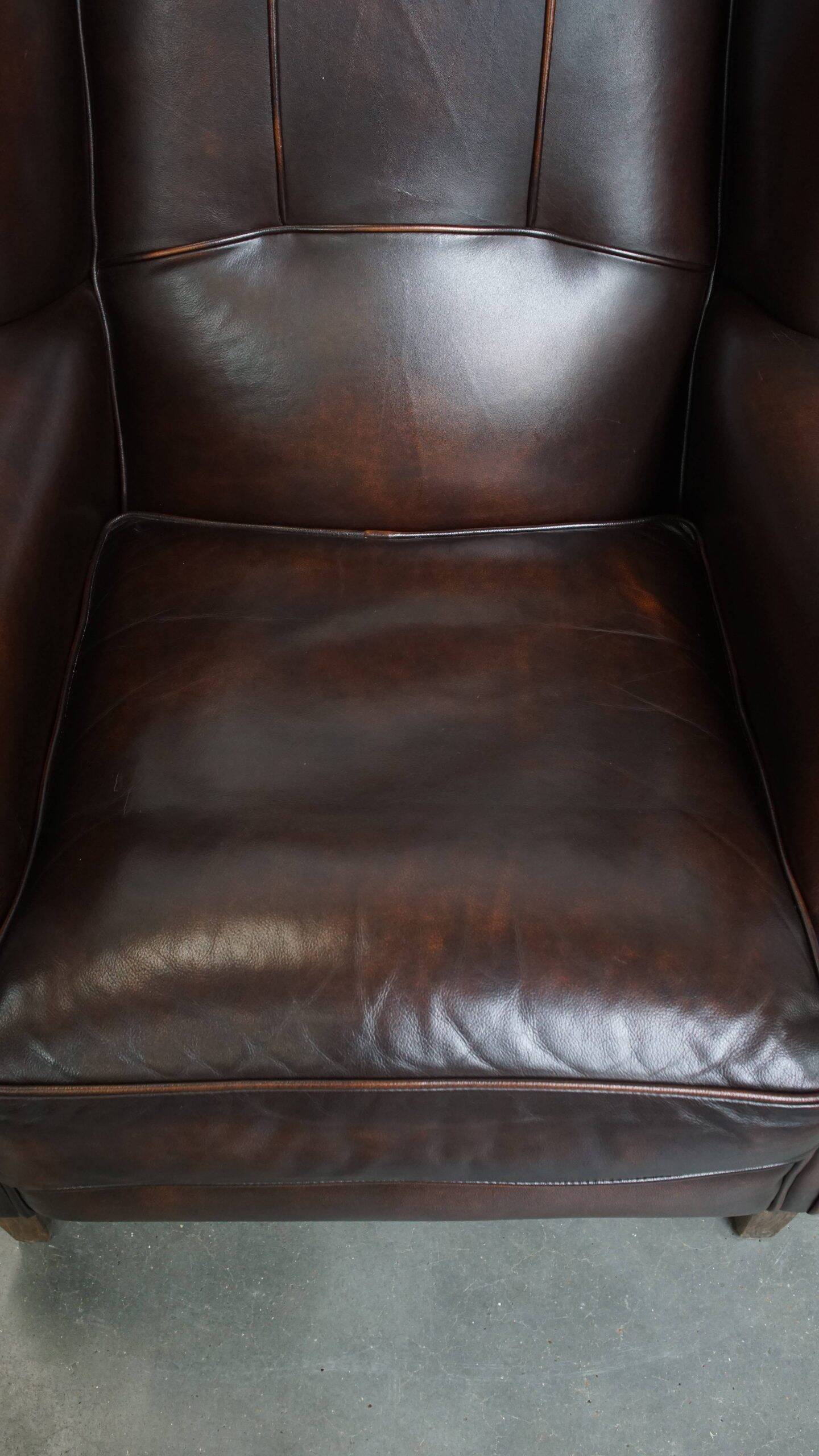 Comfortable wingback chair in English style made of cowhide leather