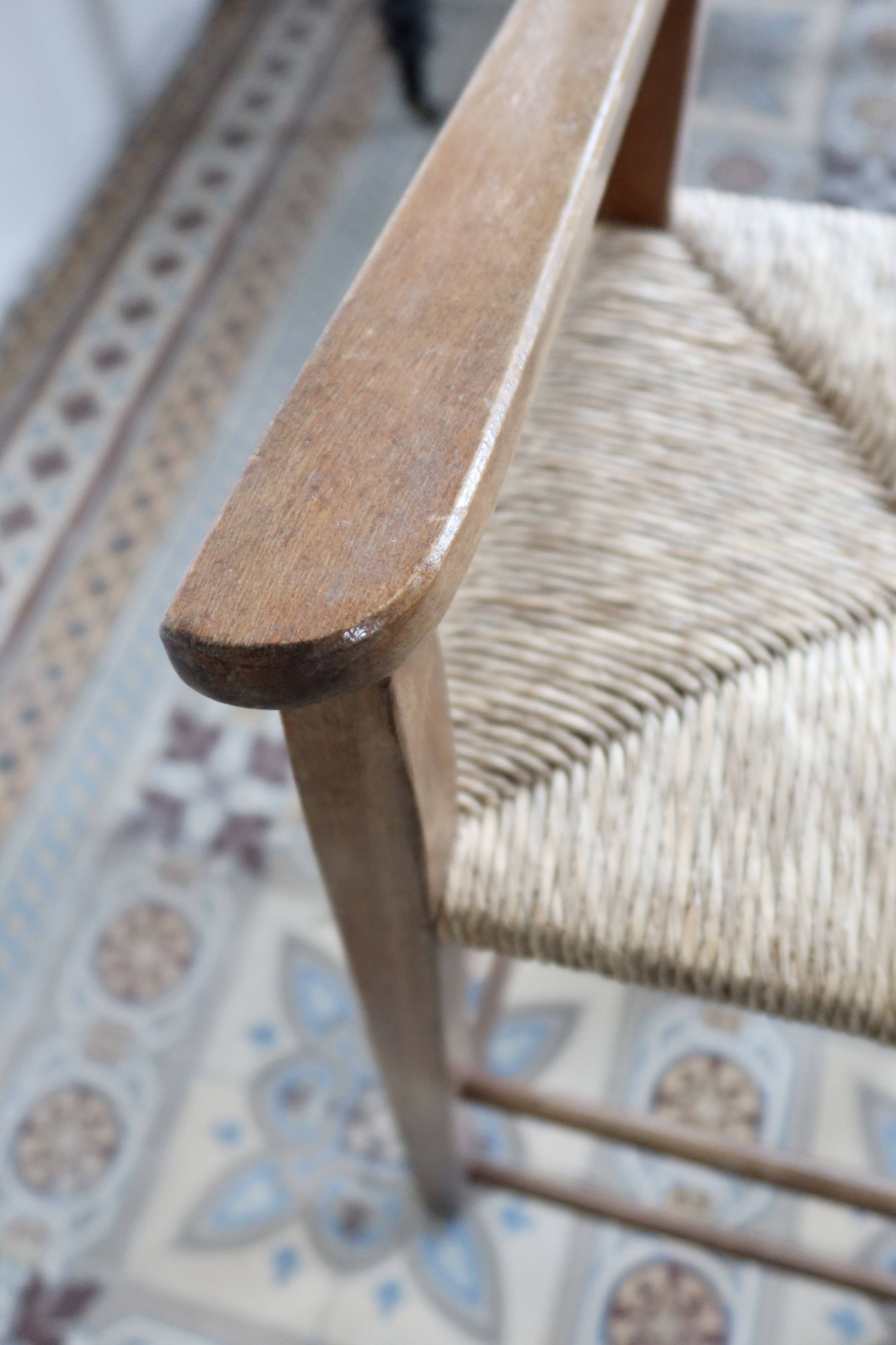 Vintage wooden high chair for children with a straw seat.