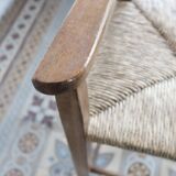 Vintage wooden high chair for children with a straw seat.