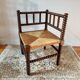 Old wooden turned spindle fireside chair with a straw seat.