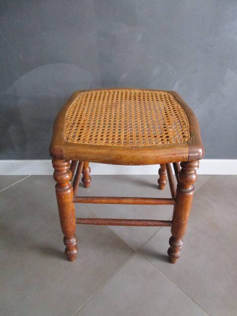 Antique wooden stool with cane seat.