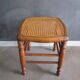 Antique wooden stool with cane seat.