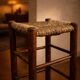 Vintage rustic style bar stool made of solid wood with a straw seat.
