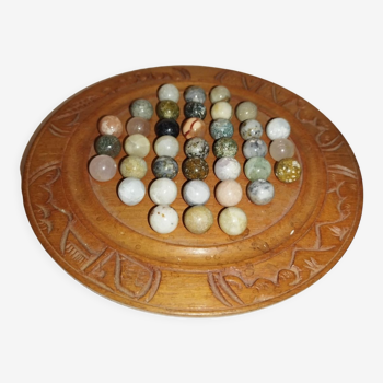 Ancient solitaire game in wood and stone marbles