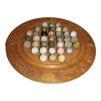 Ancient solitaire game in wood and stone marbles