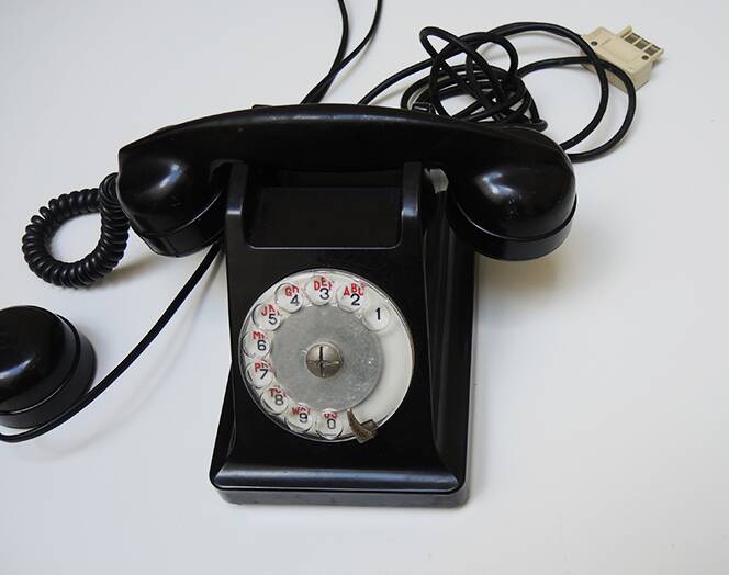 Old ptt phone with rotary dial in black bakelite