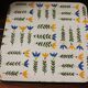 Vintage laminated wooden trivet with yellow, green, and blue flowers