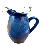 Blue ceramic pitcher with vintage artisan inscription decoration.