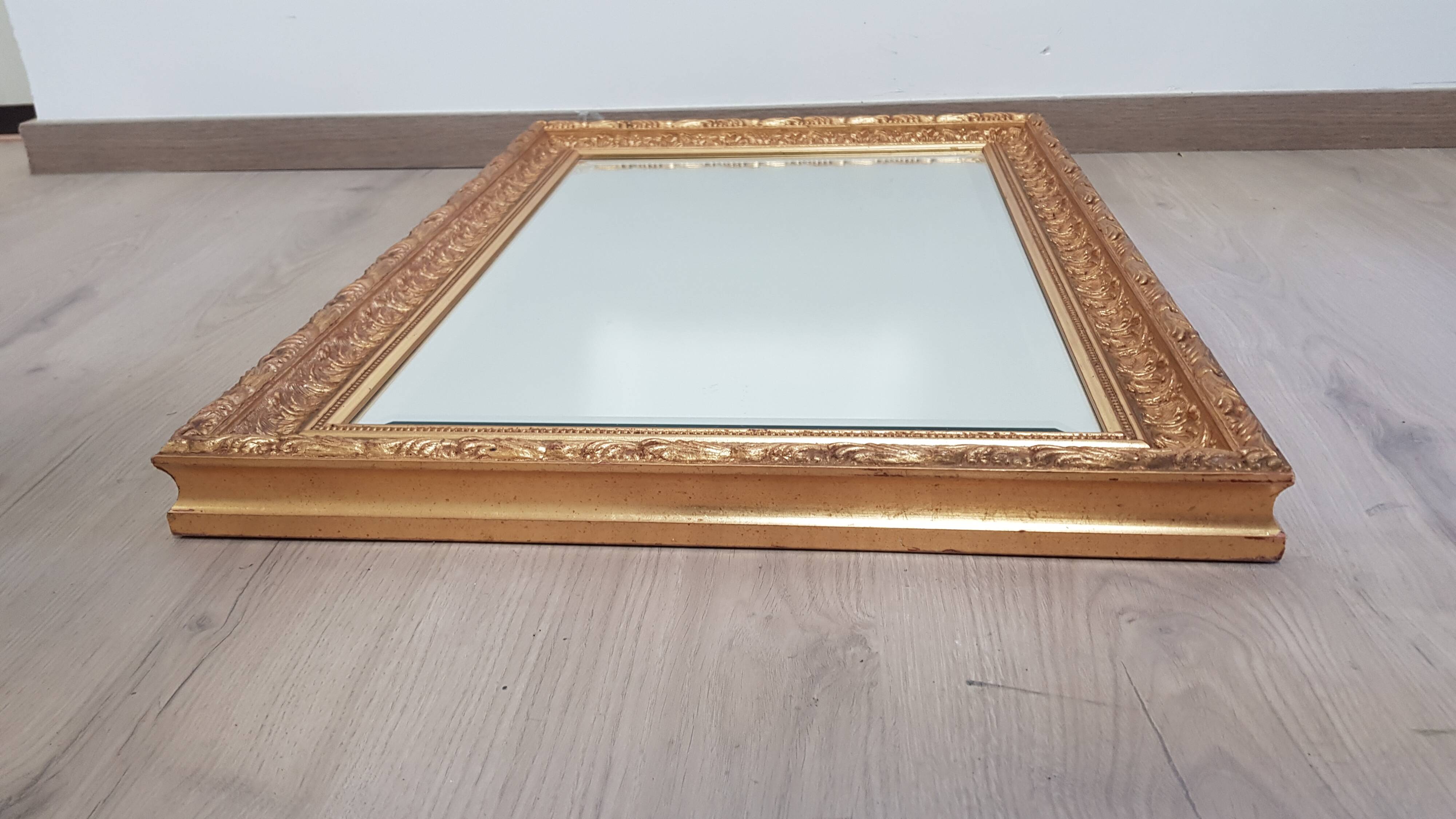 Mirror in gilded stucco wood and beveled glass