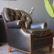 Chesterfield style leather armchair & footstool by Hancock & Moore