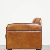 Sheepskin Art Deco design armchair with beautiful wooden details and black piping