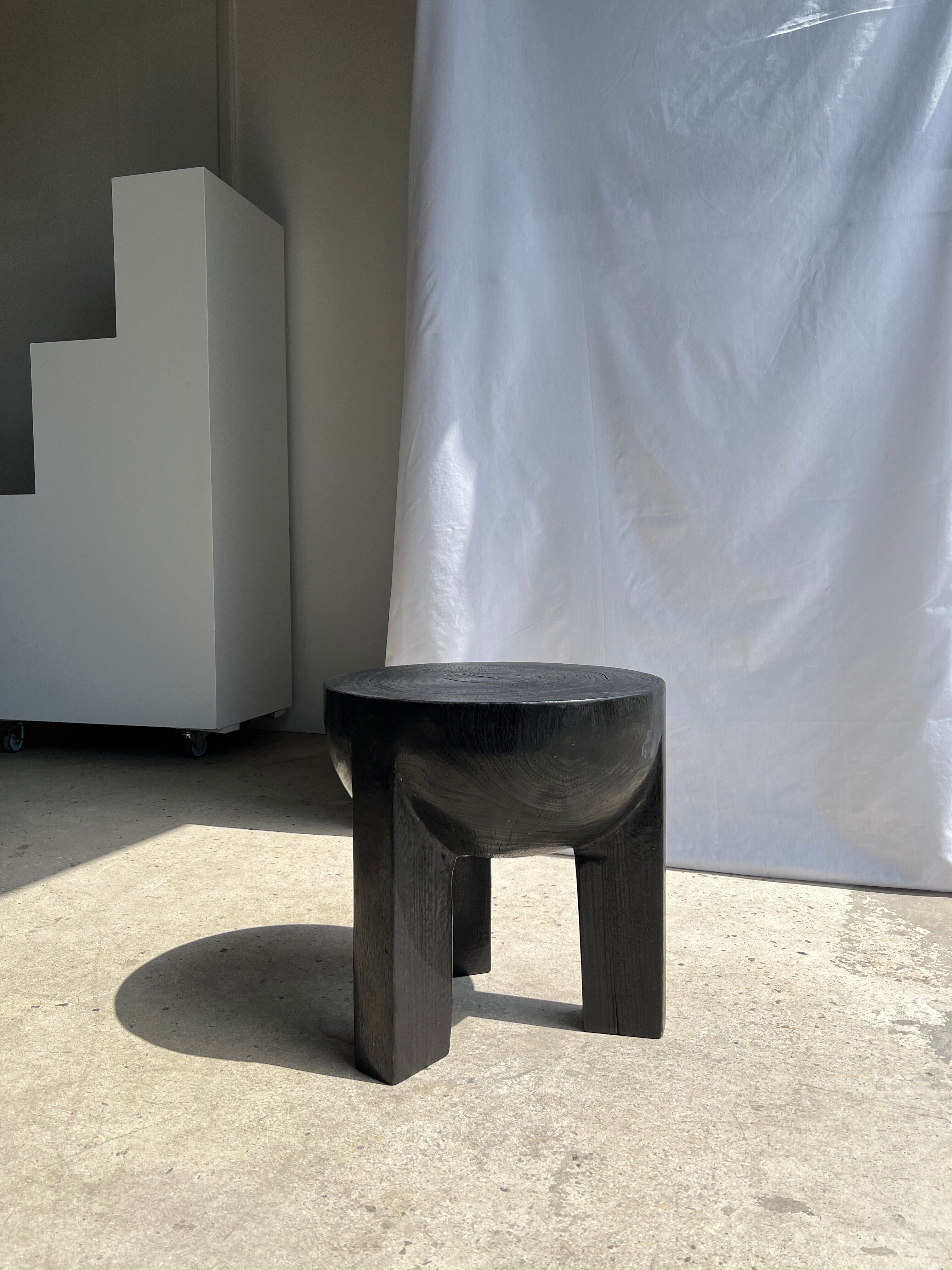 Black mango wood tripod side table with a semi-spherical top, height: 45 cm, diameter: 44 cm.