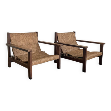 A pair of wicker armchairs.