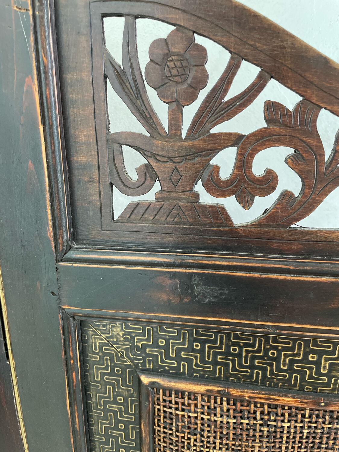 Antique wooden wall panel with carving and cane in an Asian style.