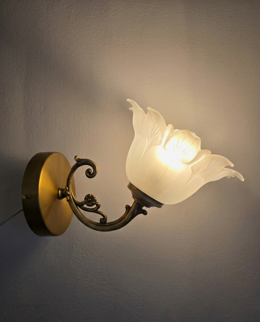 Frosted glass tulip wall sconces with brass arms.
