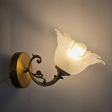 Frosted glass tulip wall sconces with brass arms.