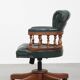 Dark green leather Chesterfield office chair on wheels.