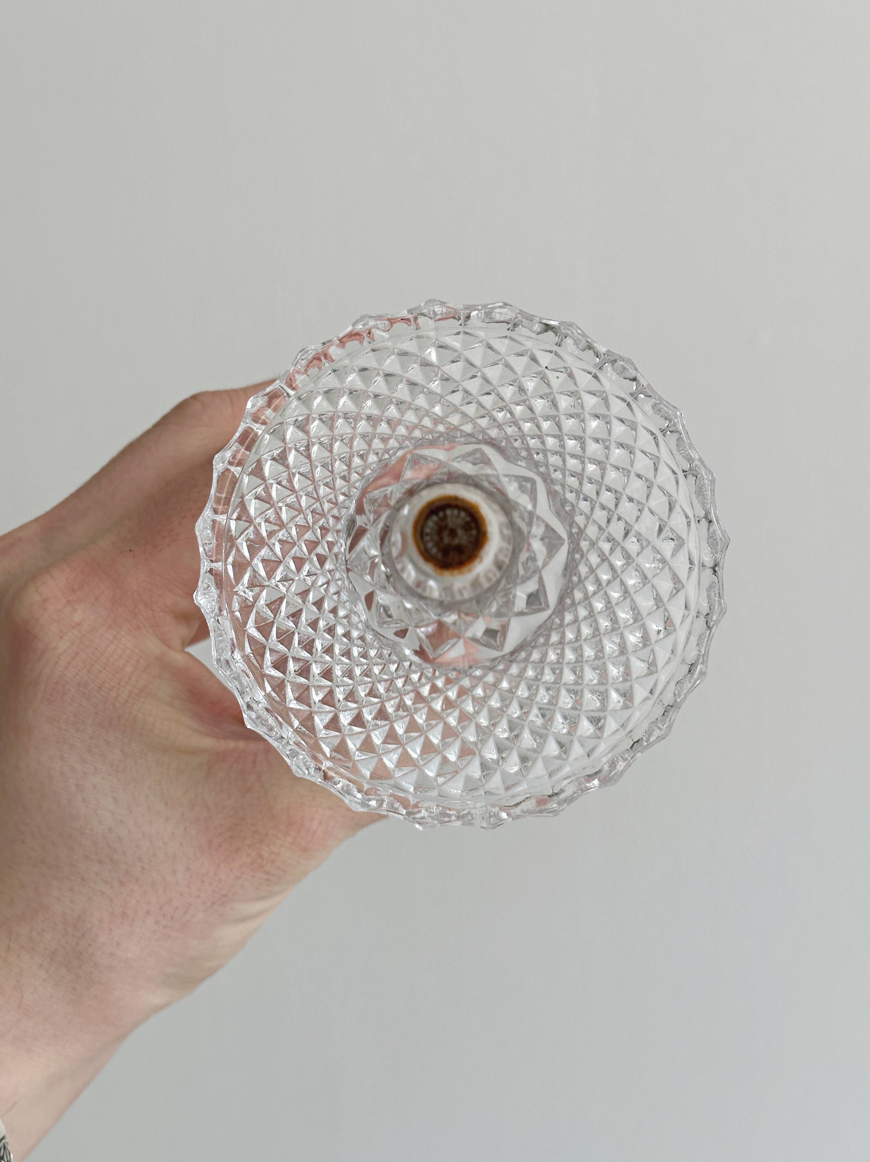 Small vase on a metal stand with thick glass.