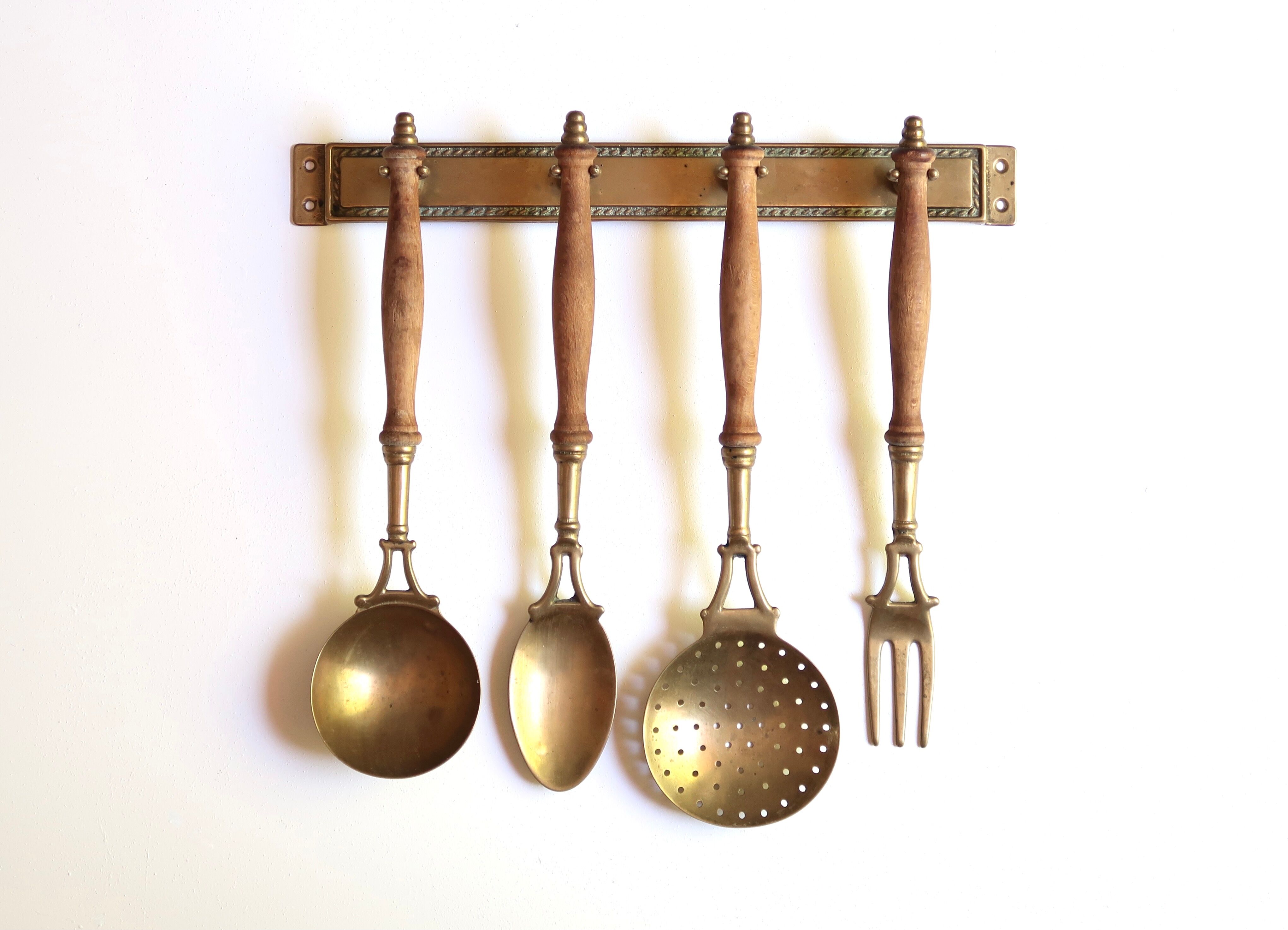 Brass and wood kitchen utensils with wall display, 60s