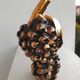 Beautiful black and gold ceramic bottle in the shape of a bunch of grapes.