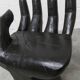 Black armchair chair in carved wood in the shape of a hand