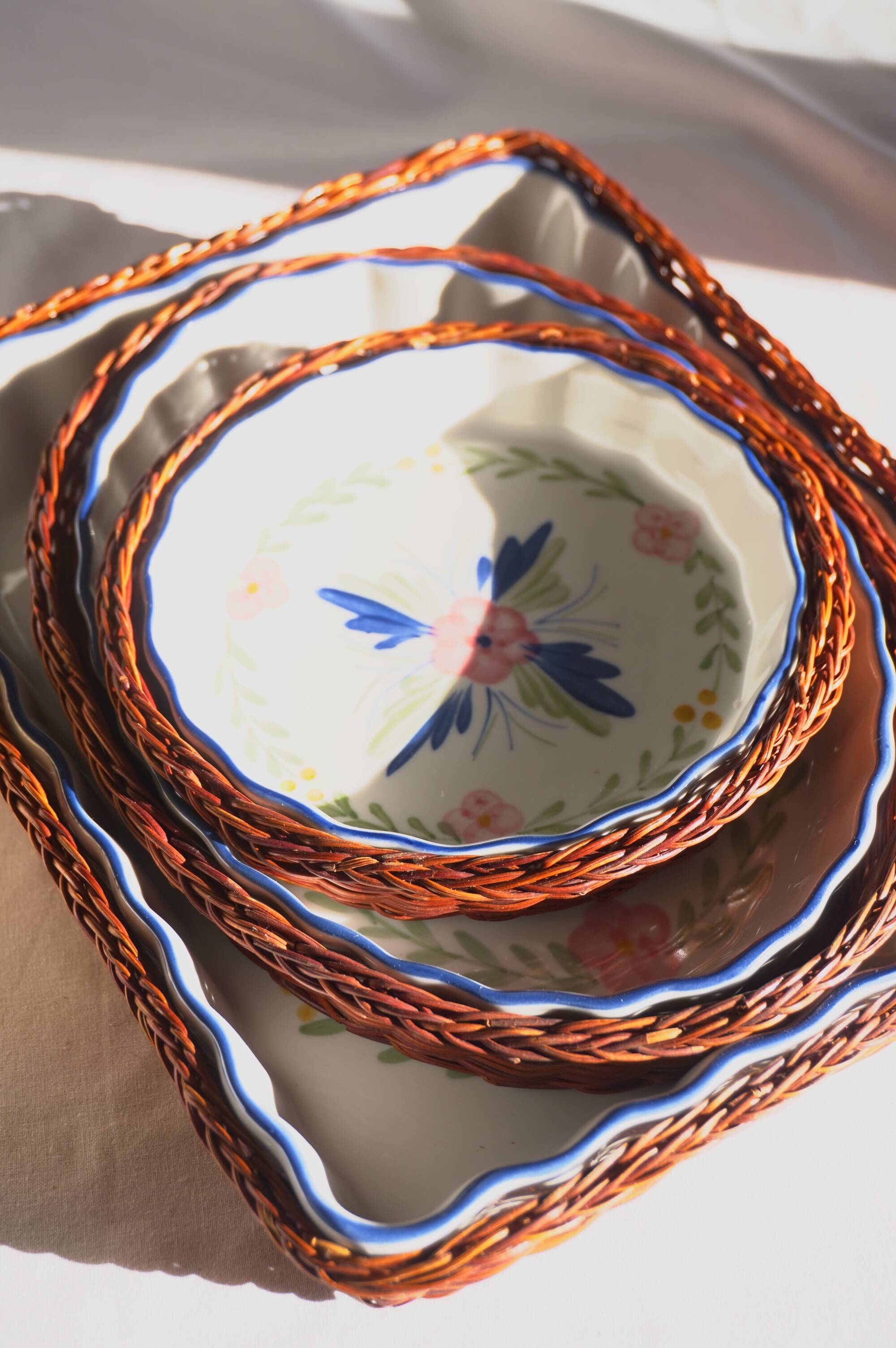Set of 3 porcelain dishes with floral decorations, with wicker supports.