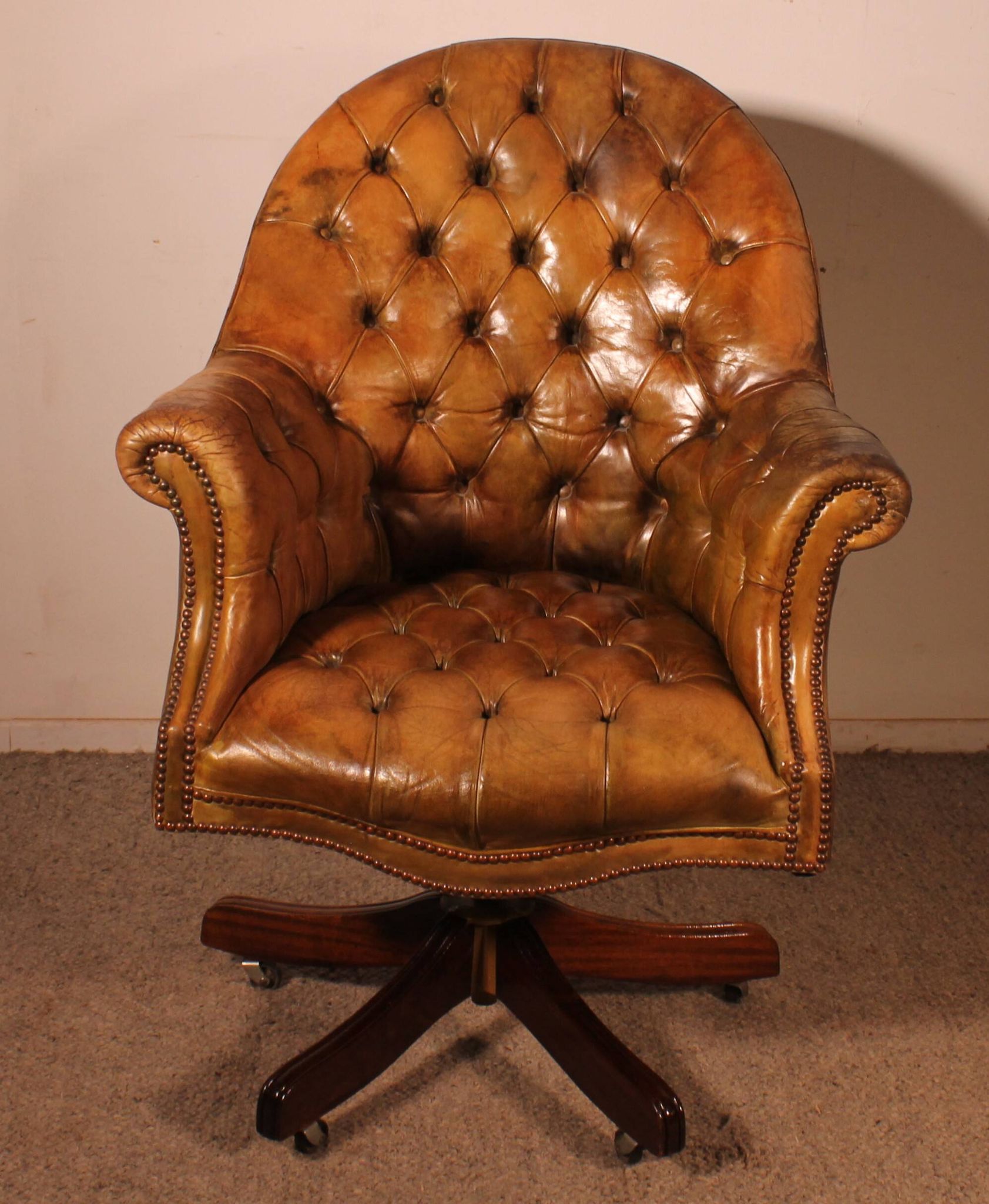Office chair known as a presidential chair in mahogany and cognac leather.
