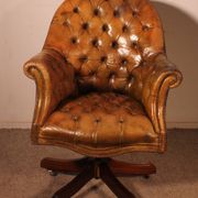 Office chair known as a presidential chair in mahogany and cognac leather.