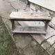 Small country bench in grey pine, rustic antique style with storage shelf.