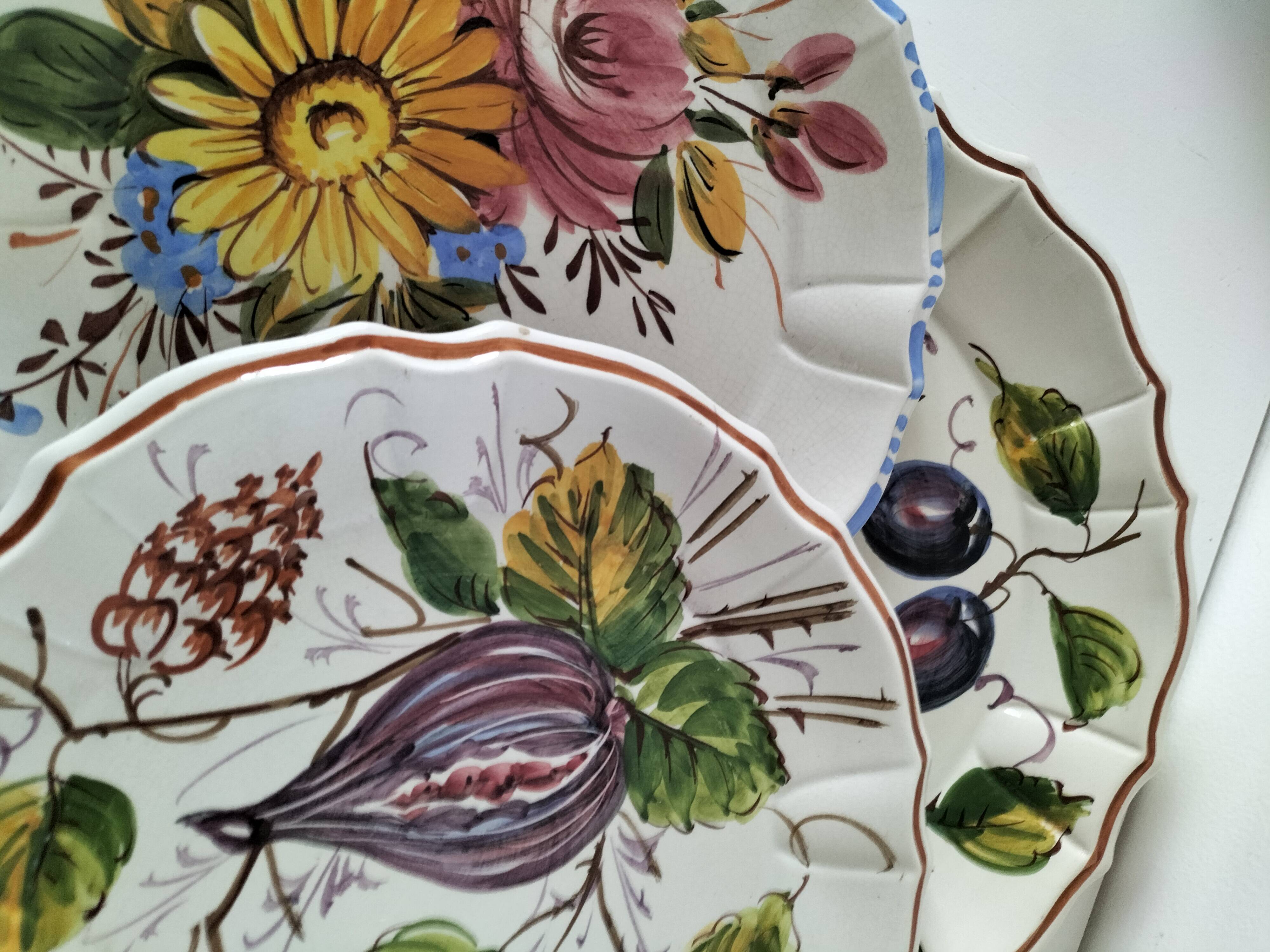 Set of three earthenware plates from Bassano, hand-painted with fruit and flower designs.