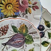Set of three earthenware plates from Bassano, hand-painted with fruit and flower designs.