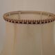 Mid-century French table lamp made of turned carved wood with a fringed shade.