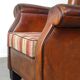 Very large worn sheepskin wing chair with a checked seat cushion