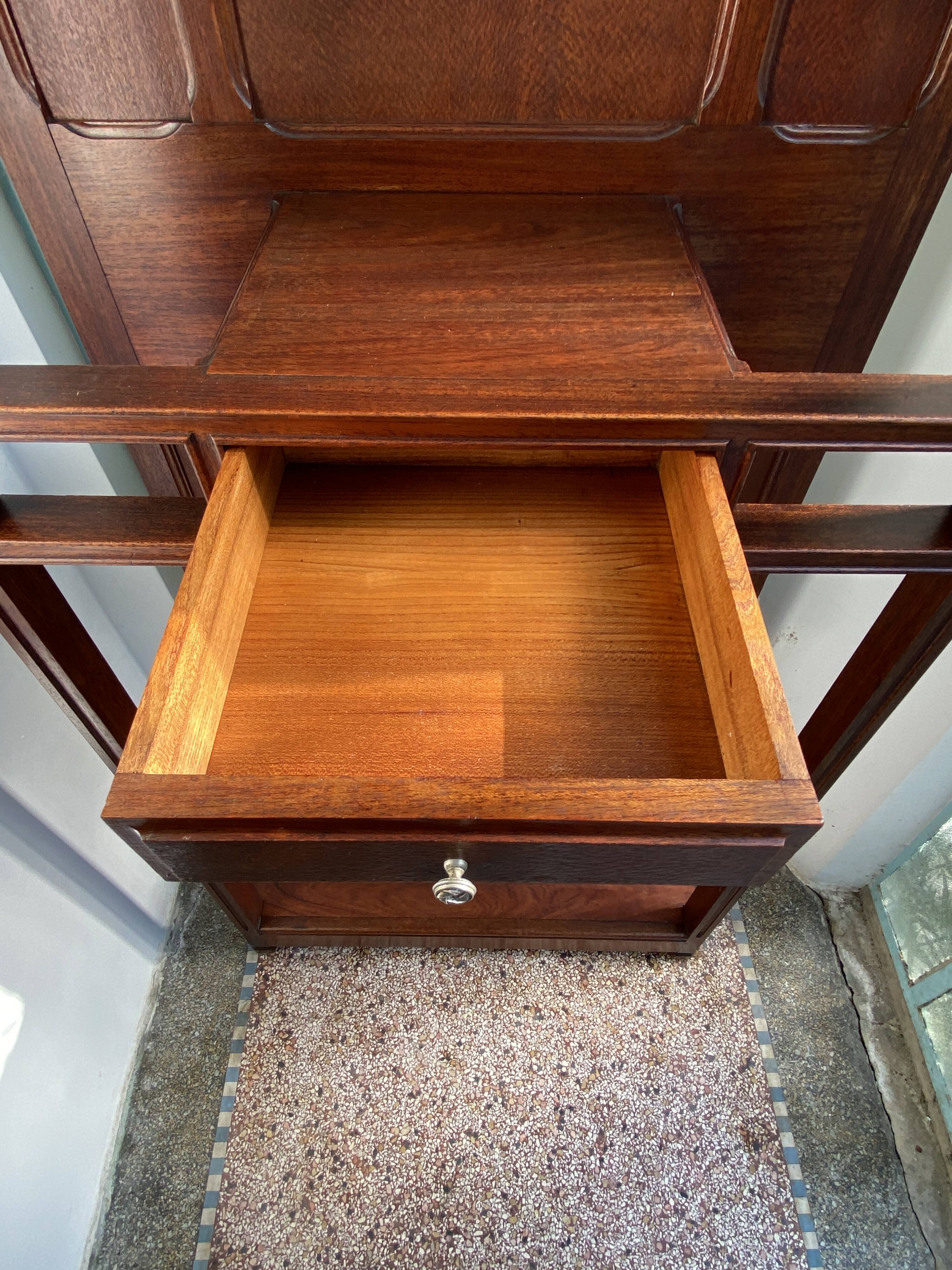 Antique wooden coat rack with mirror and shelf.