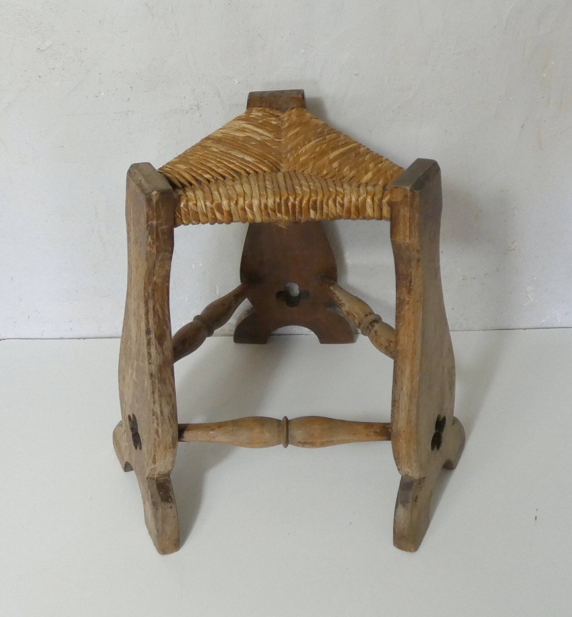 old wooden and straw tripod stool